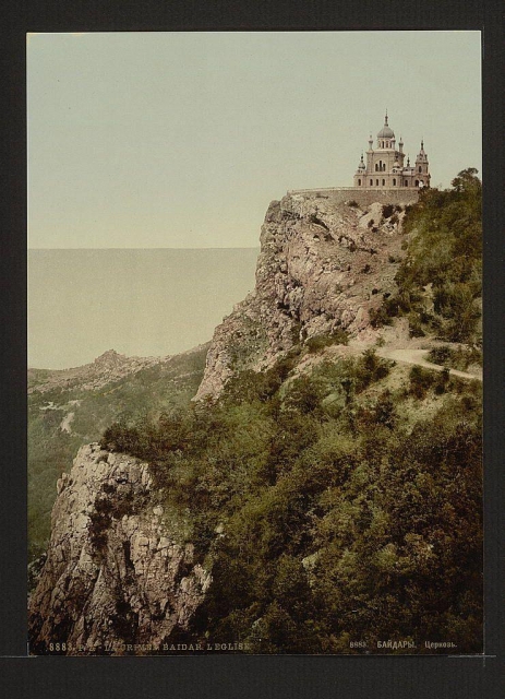 The image depicts a historic church situated on an elevated cliff overlooking what appears to be the sea. The architectural style of the building suggests it may have been constructed in the late 19th or early 20th century, with features such as domes and towers that are characteristic of Eastern Orthodox Christian churches found in regions like Russia and Ukraine during this period.

The photograph is monochromatic, likely a vintage print from around the turn of the last century. The steep cliff on which the church stands adds to its imposing presence against the serene backdrop of the sea or ocean below. Vegetation can be seen along the edge of the cliffside where it meets the rocky terrain. There's text at the bottom indicating this may have been a photochrom print, which was a popular method for printing photographs during that time.

The image is framed within what looks like an old photograph album page with visible signs of age and wear on its edges. The specific location or name associated with this church is not immediately clear from the provided information but it could be identified further through historical records or local knowledge about such sites in Russia, Ukraine, Poland, or other parts of Eastern Europe during that era.