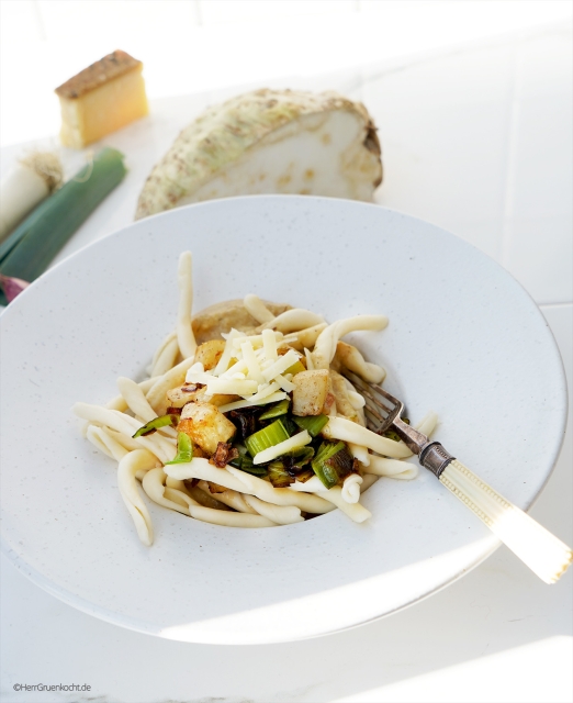 Weißer Untergrund. Darauf ein weißer Pastateller. Im Pastateller: Vegetarische Pasta mit Lauch und Sherry