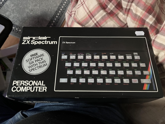 A boxed Sinclair ZX Spectrum personal computer. The box has a circular promotional label stating "FREE SOFTWARE SIX PACK WITH THIS SPECTRUM."